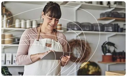 Comerciante usando um tablet na loja para gerar pedidos de compra com o assistente de compras do SysPDV