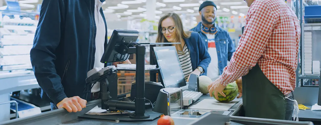 Caixa de supermercado atendendo clientes com o SysPDV, com impressora emitindo o cupom fiscal da venda