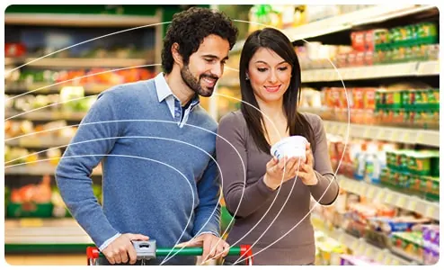 Clientes comparando produtos em promoção na gôndola de um supermercado que utiliza o SysPDV